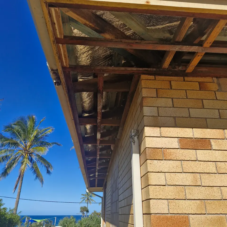Close view of exposed eaves and roof framing on a brick house
